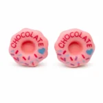 Różowe kolczyki w kształcie donuta z napisem ‘CHOCOLATE’, kolorową posypką i małym niebieskim serduszkiem na jasnym tle